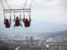 Tourists enjoy a giant swing overlooking the city on Trebevic