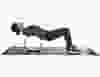 A woman in workout clothes, rolling her back on a Chirp wheel.