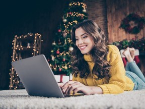 Photo of cute nice charming attractive girl woring in eve of new year with her laptop wearing jeans denim yellow sweater
