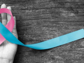 Pink blue ribbon awareness (isolated with clipping path) bow color for newborn birth defect, Sudden Infant Death Syndrome (SIDS), pregnancy Loss on helping hand