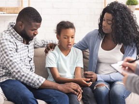 Little black girl and her parents at psychologist consultation - stock photo