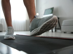Sporty man training on walking treadmill at home, closeup
