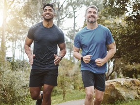 Running team, fitness and men in forest with cardio, athlete with personal trainer for support in sports and health.