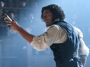 Oscar Isaac holds something in his left hand in a scene from Guillermo del Toro's Frankenstein