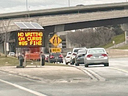 An image shared by Toronto Pearson International Airport of vehicles stopped on the curb to the airport next to a sign saying doing so could mean an $85 fine.