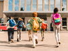 Little kids schoolchildren pupils students running hurrying to the school building for classes lessons from to the school bus. Welcome back to school. The new academic semester year start - stock photo